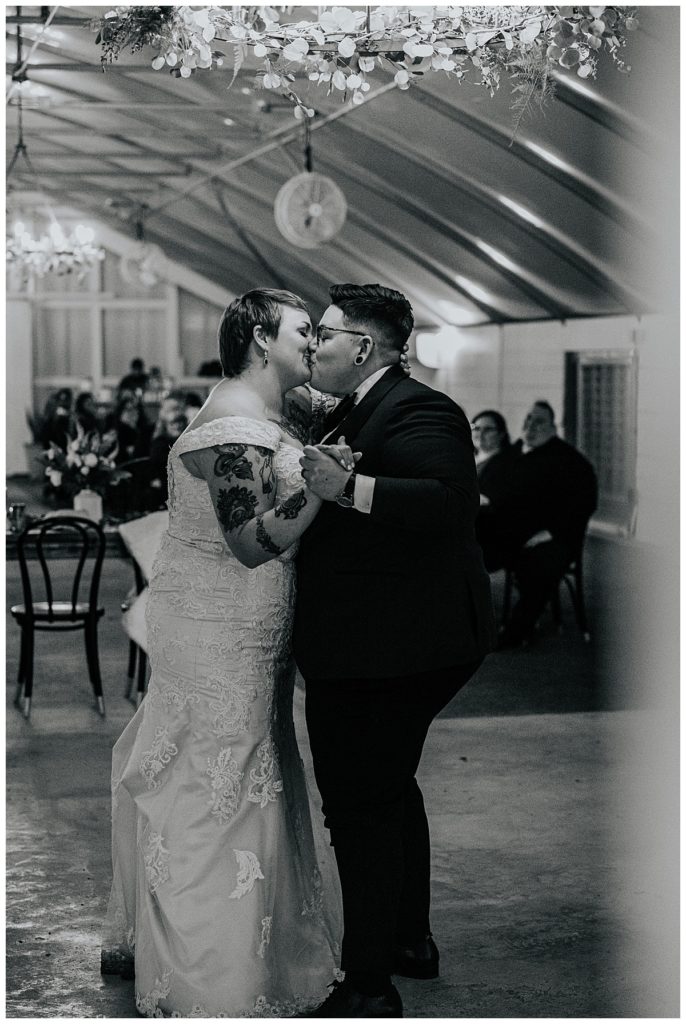 partners kiss on the dance floor by Ellie Chavez Photography