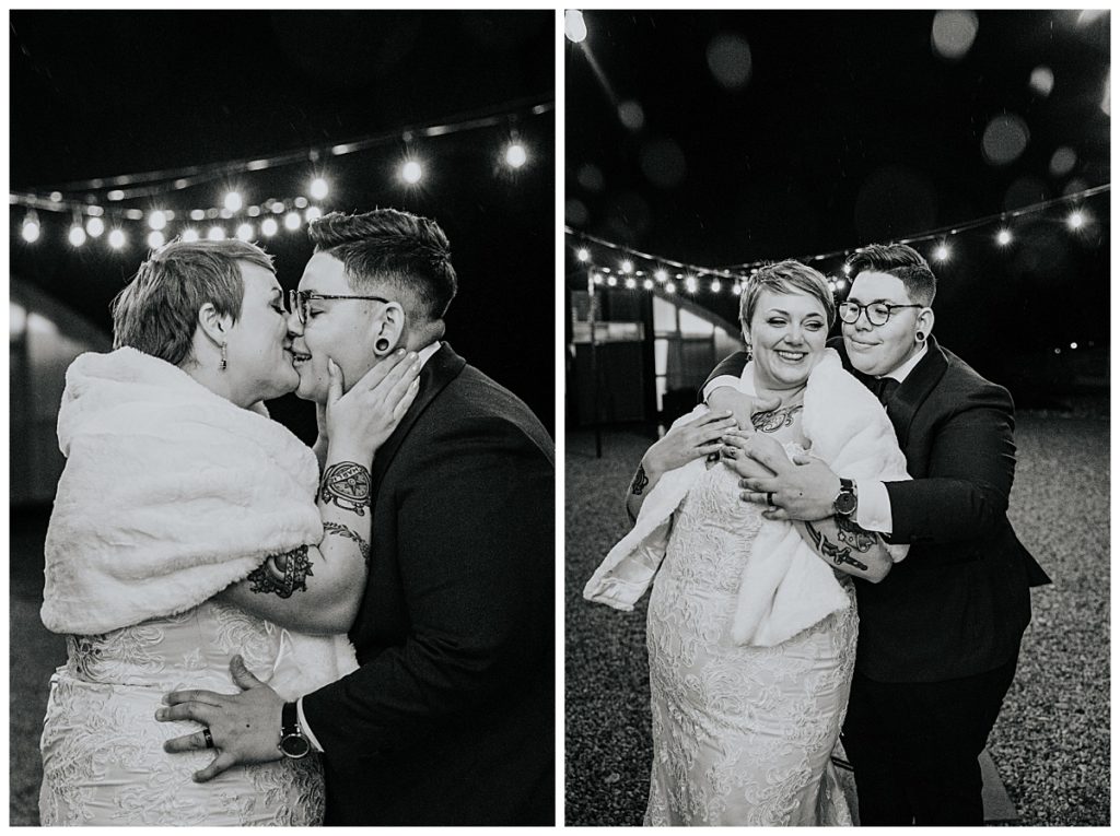 couple kisses and holds each other under lights by Austin wedding photographer