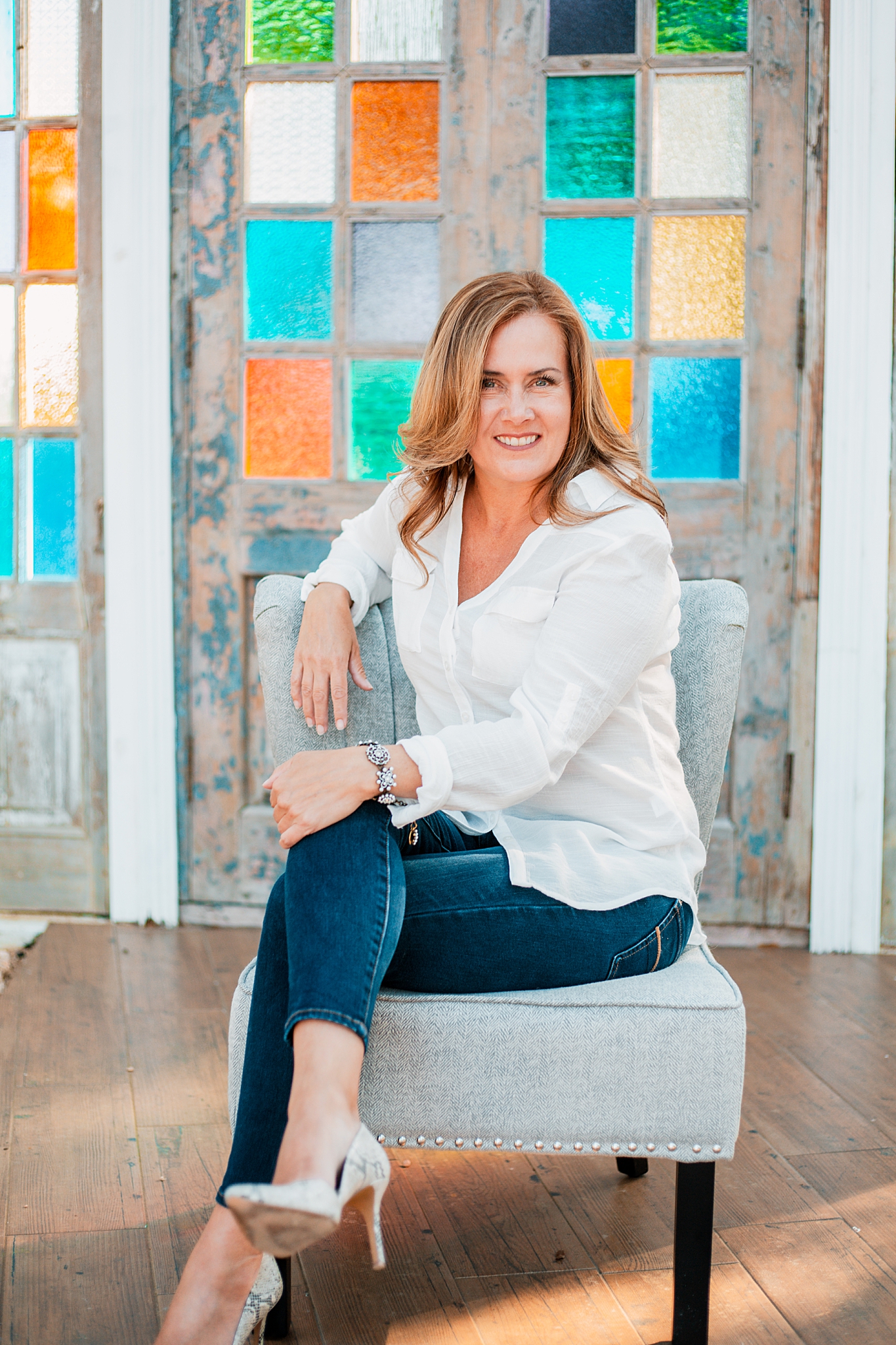 business owner crosses legs and smiles by Austin photographer