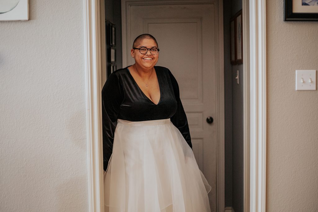 smiling person wears black top and white skirt by Austin Wedding Photographer