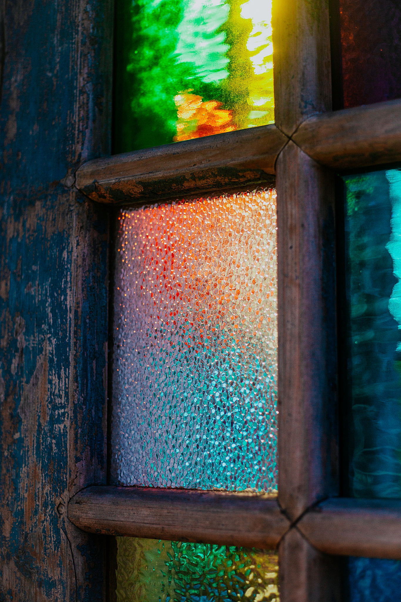 close up of colored glass in window by Ellie Chavez Photography