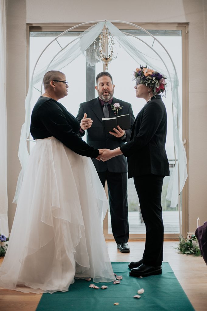 officiant speaks while partners hold hands at ceremony by Austin Wedding Photographer
