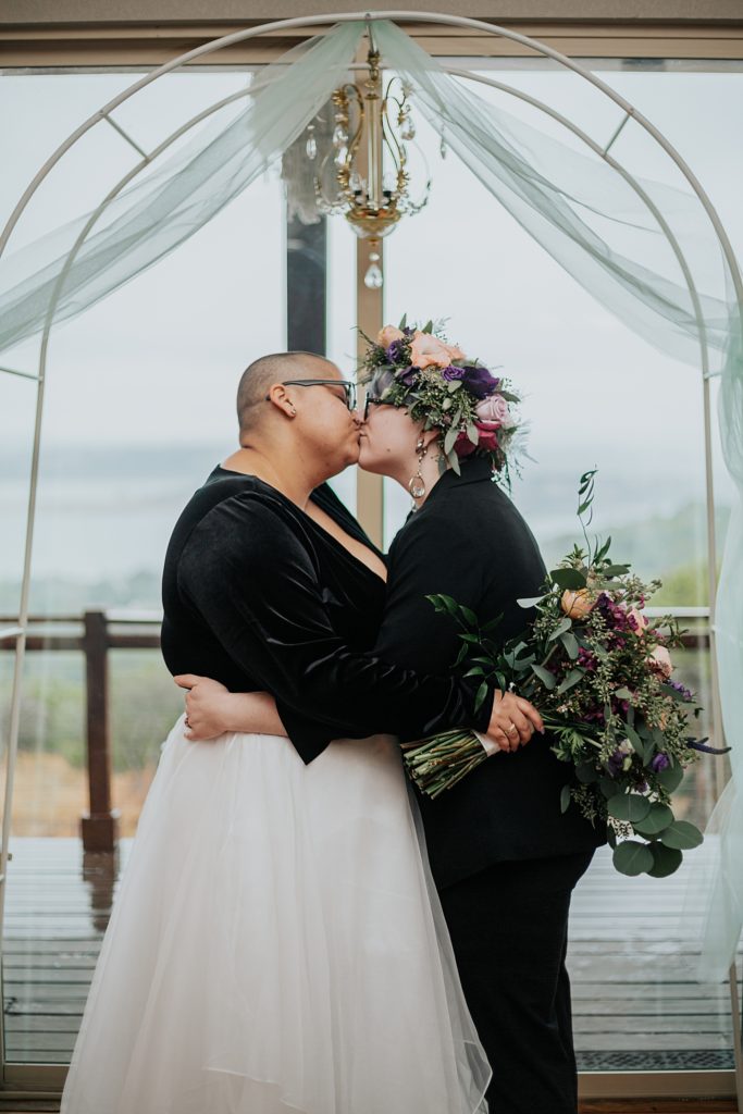 lovers kiss under arch by Ellie Chavez Photography 