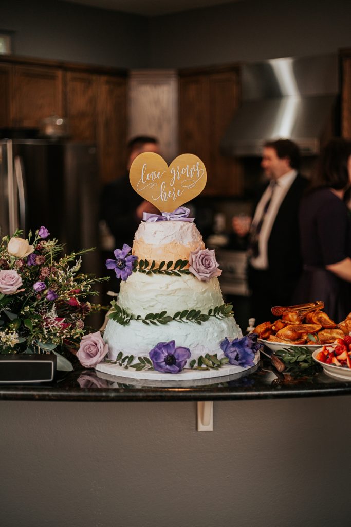 wedding cake decorated with purple flowers and greenery by Ellie Chavez Photography 