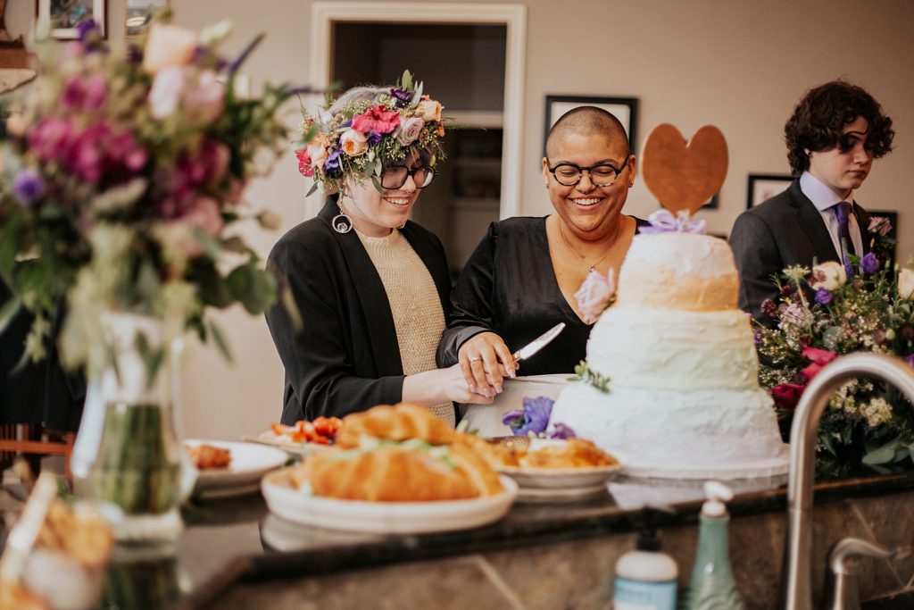 lovers cut wedding cake together by Ellie Chavez Photography 