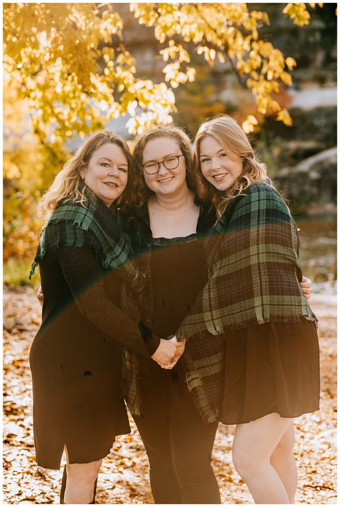 mom and daughters hug each other for family park session