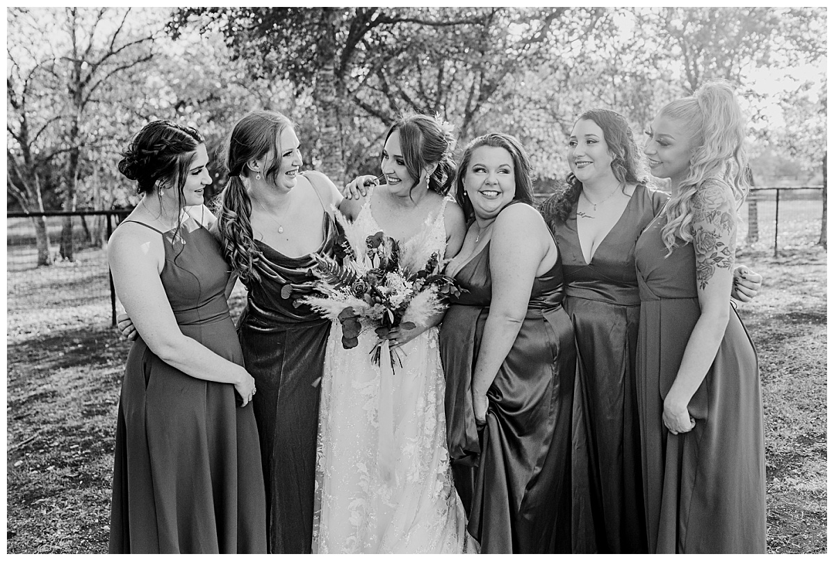 Bridesmaids smile and put their arms around each other by Ellie Chavez Photography 
