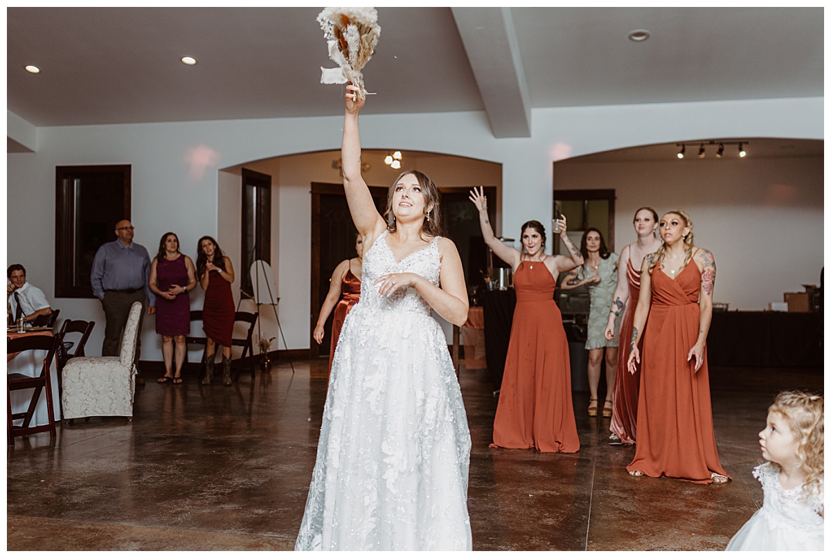 Bride throws bouquet to waiting guests by Ellie Chavez Photography 