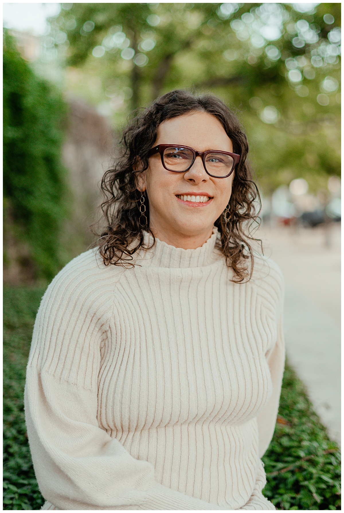 Woman in bold maroon glasses smiles at South Congress portrait session