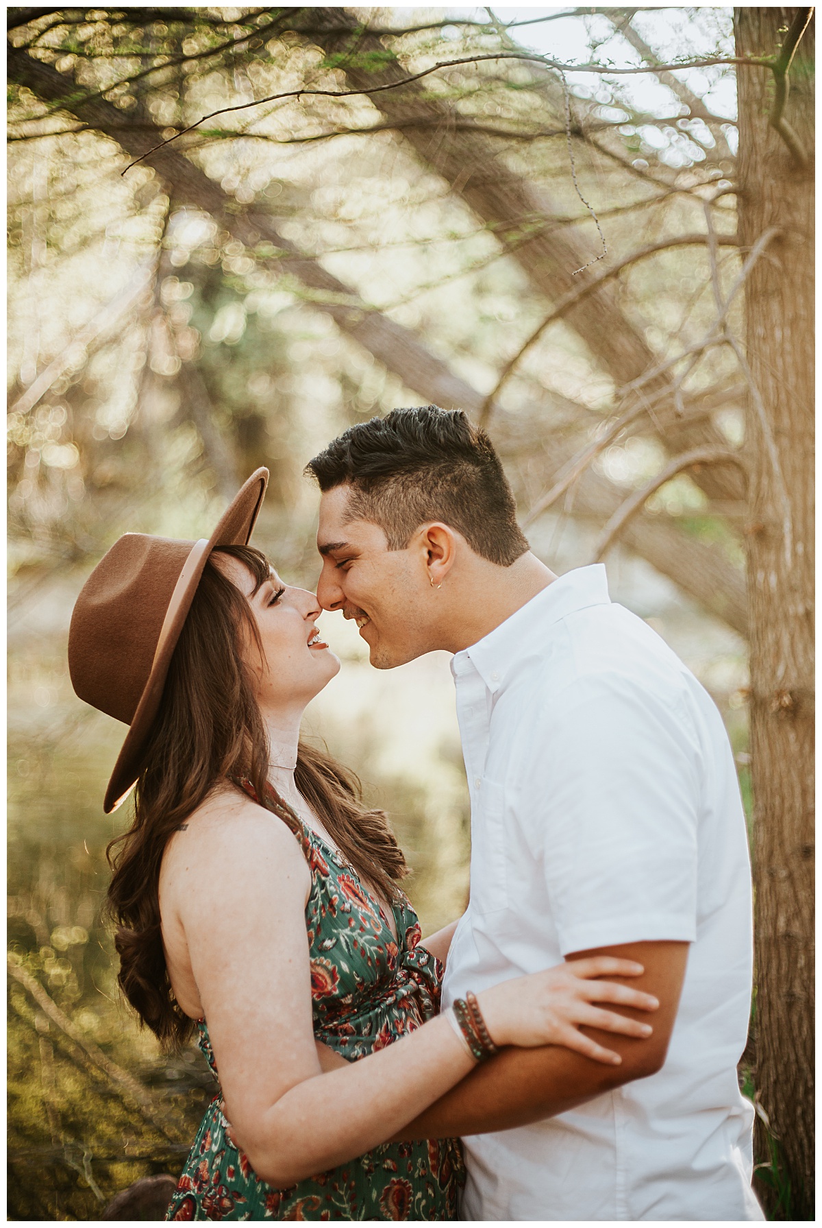 guy and girl tough noses in front of trees by Ellie Chavez Photography