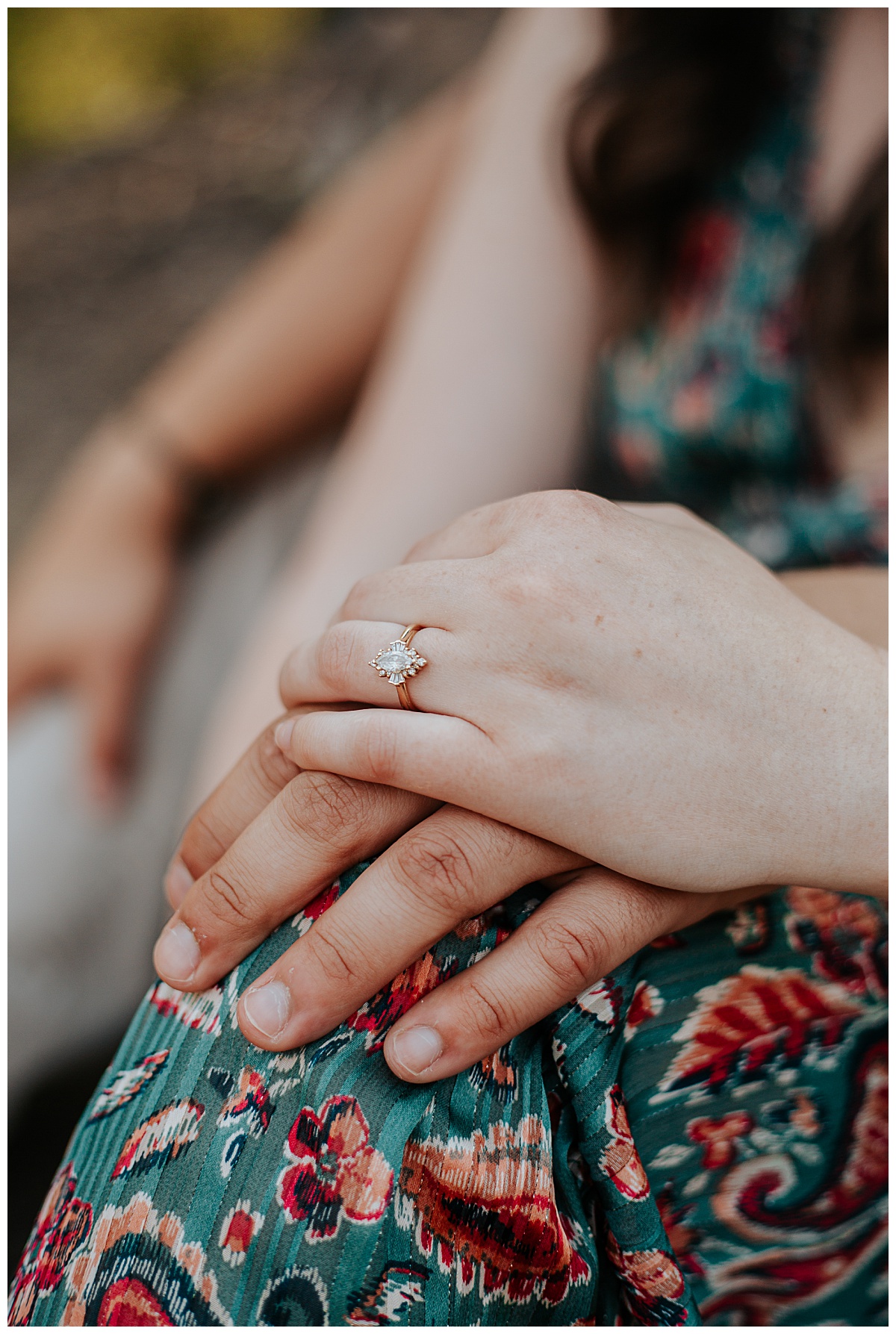 showing off hands with rings resting on knee during park engagement session